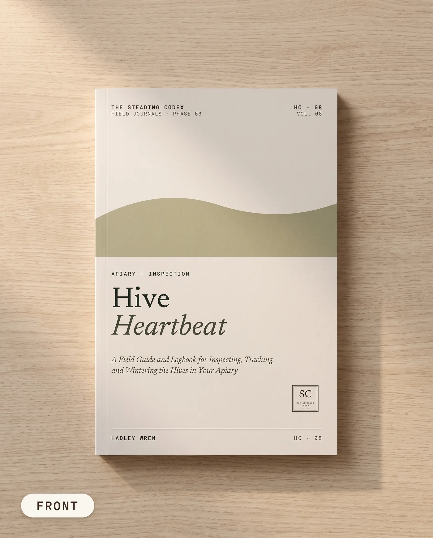 Hive Heartbeat beekeeping journal — front cover on an oak table