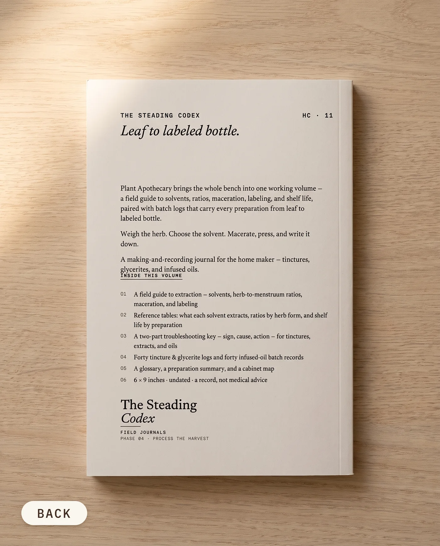 Plant Apothecary herbal preparation journal — back cover on an oak table