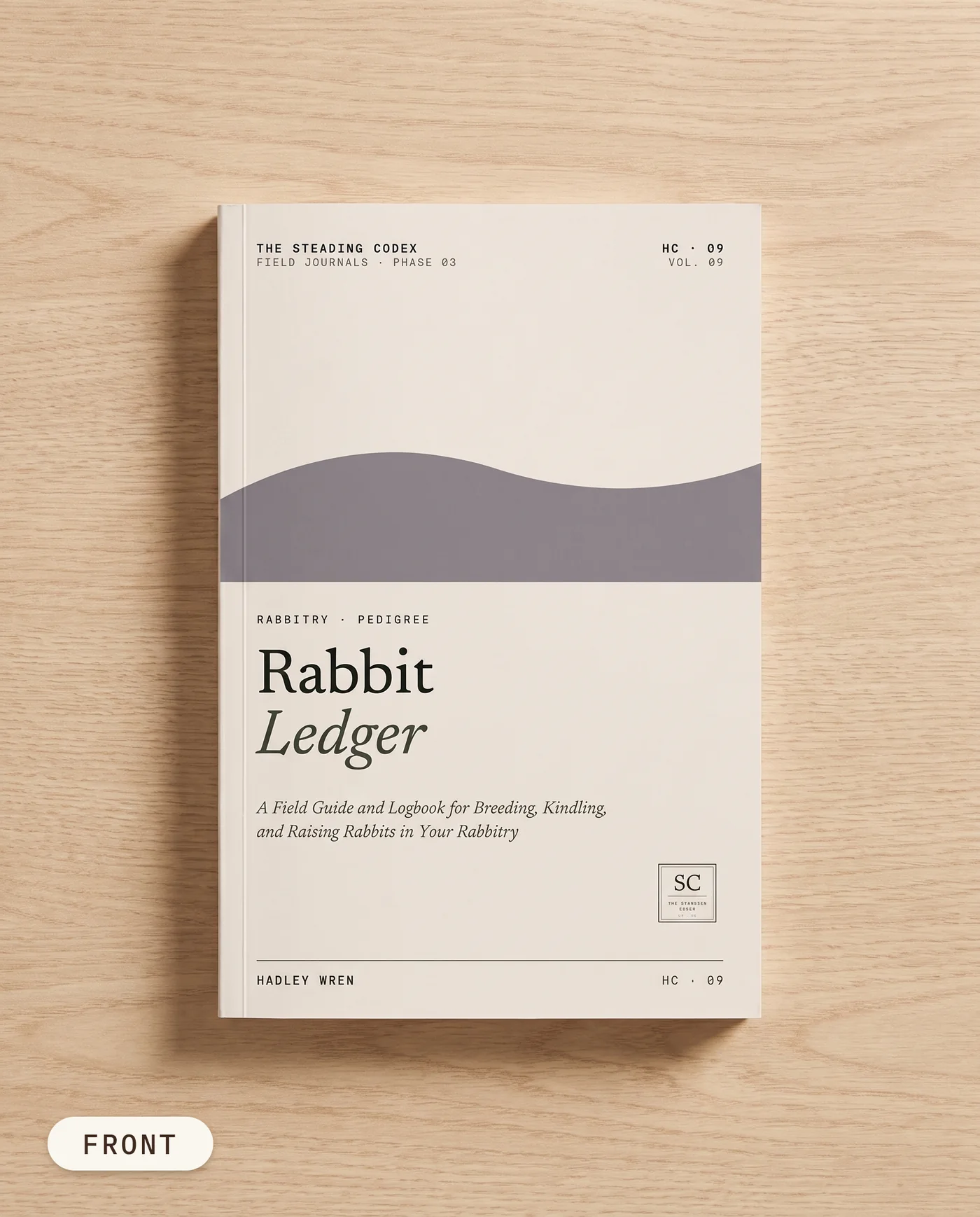 Rabbit Ledger rabbitry journal — front cover on an oak table